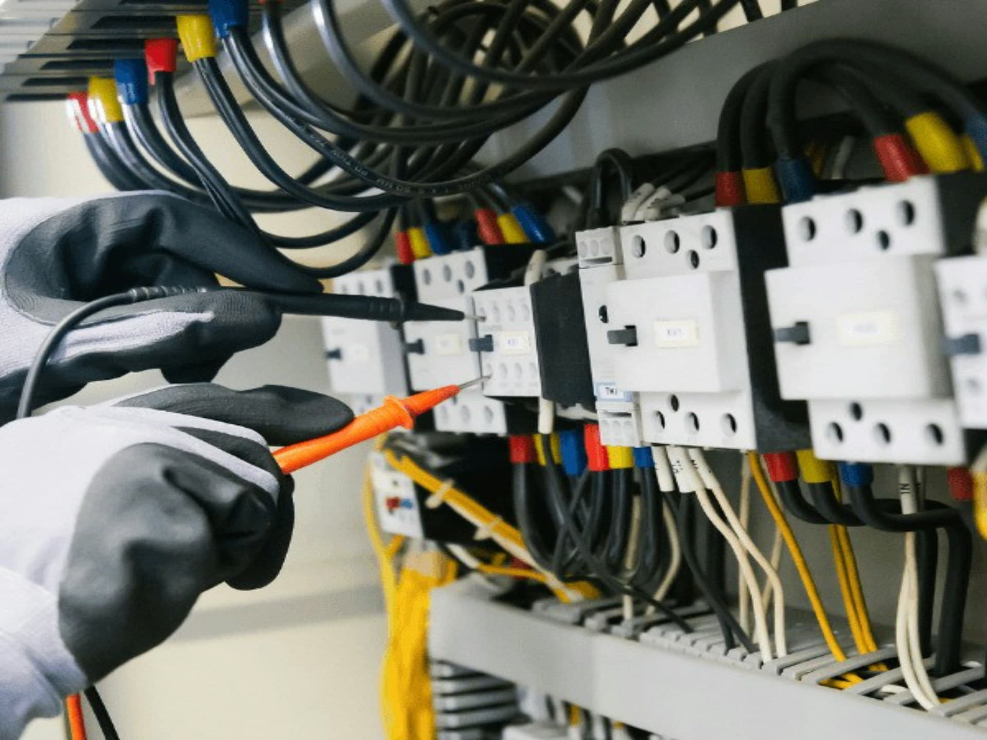 Electrical — an electrician testing a control panel with a multimeter