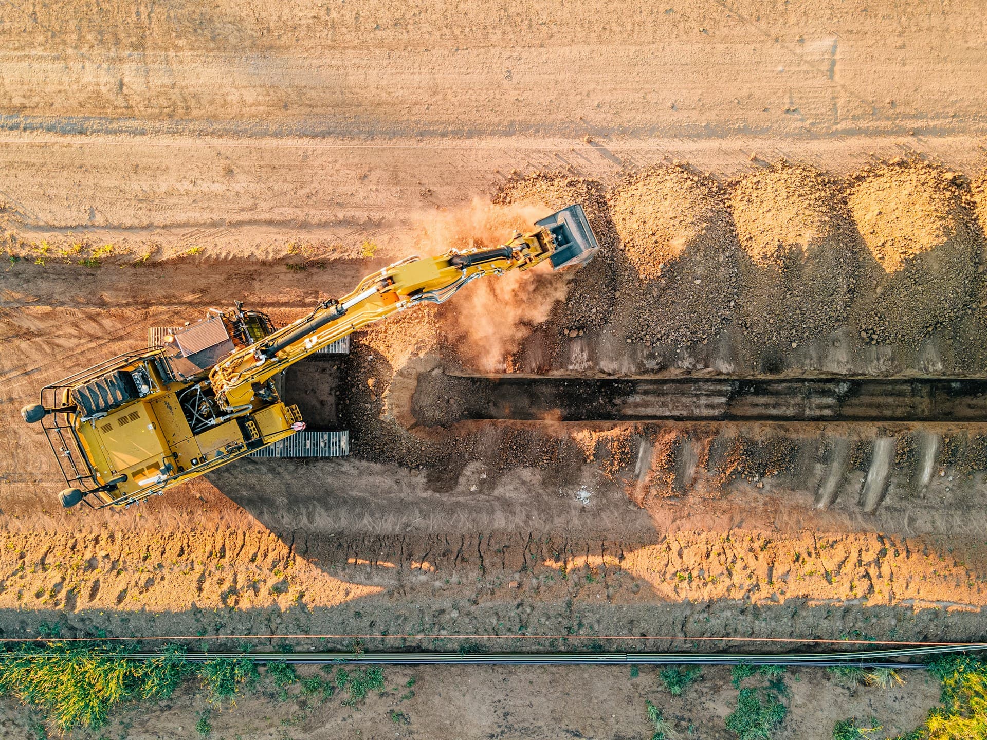 Earthworks — an excavator digging a trench through dirt