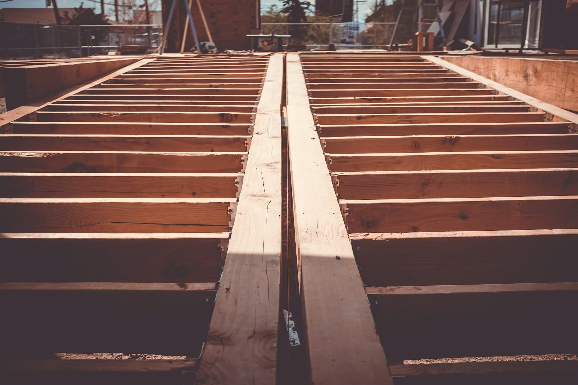 Timber floor joists and a central bearer framed over a building foundation